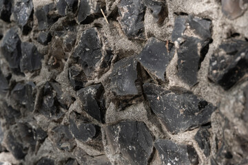 Black quartz stones in concrete are part of the mosaic, close-up.