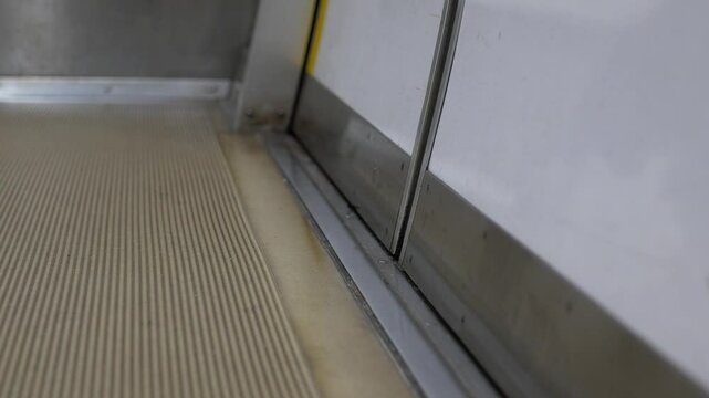 low angle with selective focus view to train subway door while door is closing ready to depart from flatform train station. public train transportation door closing with selective focusing