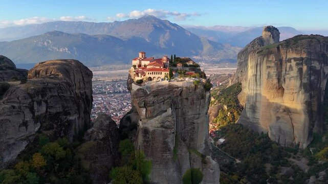 Aerial sunrise view view of Meteora mountains with Agia Triada monastery situaded on a cliff high over the city of Kalabaka, Greece