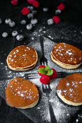 delicious pancakes with berries on a dark background. morning. breakfast