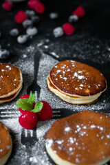 delicious pancakes with berries on a dark background. morning. breakfast