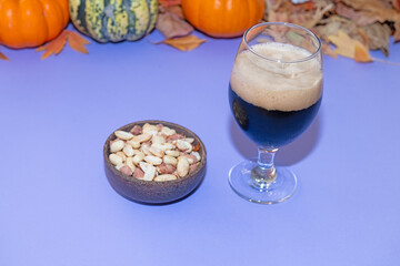 Black beer on the table and a bowl of roasted peanuts.