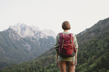 Young woman traveler in Alps mountains. Travel and active lifestyle concept.