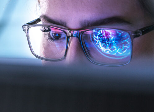 Young doctor researching on patients brain MRI and using computer with AI technology