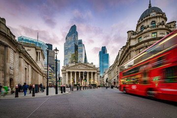 Sunset view of the City of London, England, with commuter and street traffic in front of the Bank...
