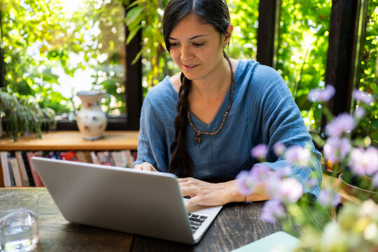 Smiling freelancer working on laptop in gazebo