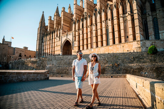 Tourists couple walking near Palma Cathedral