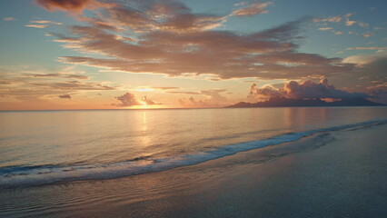 Golden sunset illuminate tranquil ocean, Moorea island in background, tropical paradise scene in...