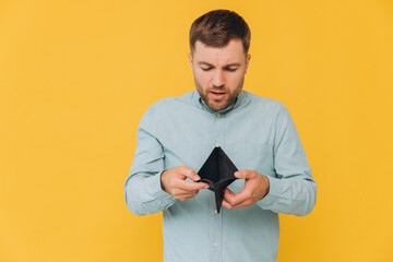 I'm Broke. Portrait of sad unshaven male bankrupt showing his empty wallet looking at camera. Upset...