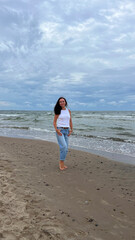 Fashionable attractive woman with long black hair on the shore of the Baltic Sea. Latvia