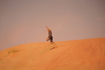 Naklejka premium woman jumping in the desert