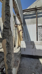 Obraz premium Interior of Damaged Residential Home, Apartment Building Room Part Construction Site After Earthquake with Unfinished Demolition of Cracked Columns and Walls on a Hot Sunny Day Clear Blue Sky Roofless