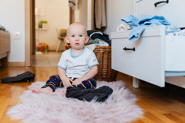 Baby boy sitting on fur rug at home