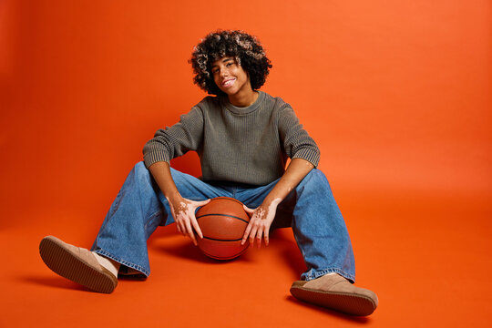 Smiling woman posing with basketball against red backdrop