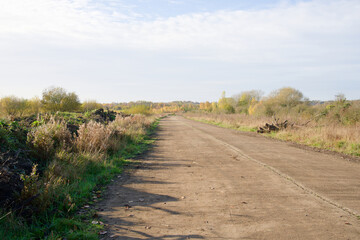 Long straight deserted road through wasteland