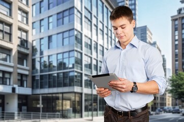 Young businessman posing outdoor at office building.