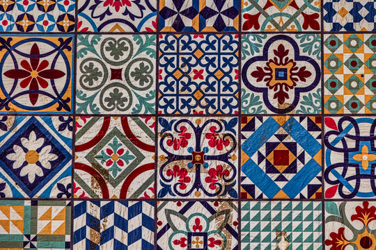 A collection spanish  of decorative ceramic tiles displays an array of intricate patterns and vibrant colors, including blues, reds, and greens