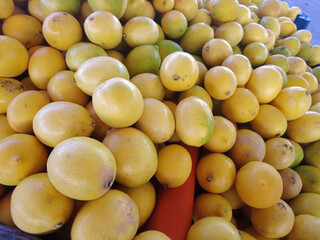 Yellow ripe juicy lemons on display in a greengrocer's stall.