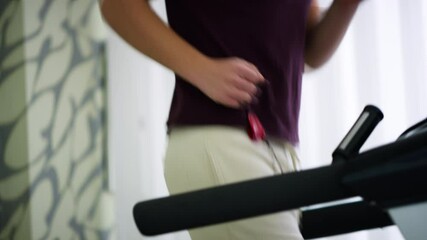 Close-up footage of a person running on a treadmill as part of a rehabilitation session indoors, focusing on controlled movement and recovery. Concept of physiotherapy and physical rehabilitation