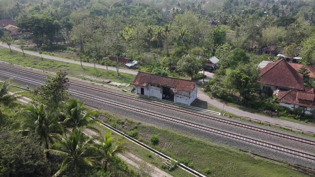 aerial drone shot, kalimenur station. An old and historic inactive station passed by a double track railway that is still active today.