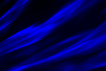 Defocused abstract blue background of speed camera movement over glowing lights. A pattern of flashes of light similar to the northern lights