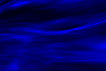 Defocused abstract blue background of speed camera movement over glowing lights. A pattern of flashes of light similar to the northern lights