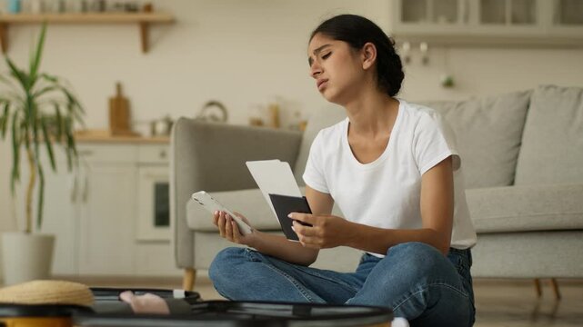 Upset frustrated stressed Hindu woman Indian girl Arabian female at home prepare for trip suitcase vacation travel cancel fly mobile phone notification problem failure cancelled hold tickets passport