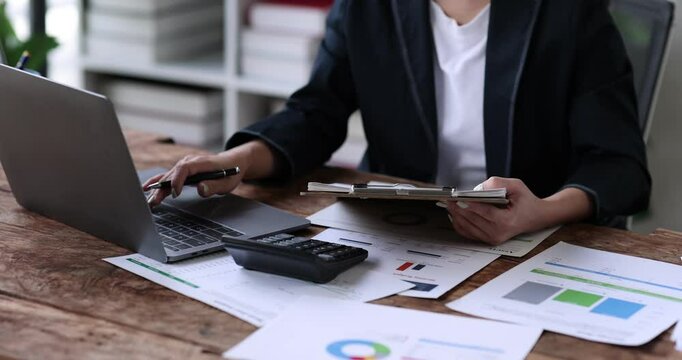 Business financing accounting banking concept. Business woman hand doing finances and calculate on desk about cost at home office. Woman working on desk with using calculator, finance accounting.
