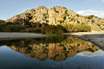 Fototapeta premium Rock reflection in the water in the evening light on the coast in Greece