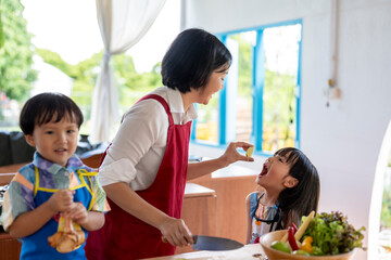 Asian family cooking together having fun with food in kitchen