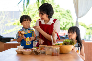 Fototapeta premium Asian family cooking together in kitchen at home