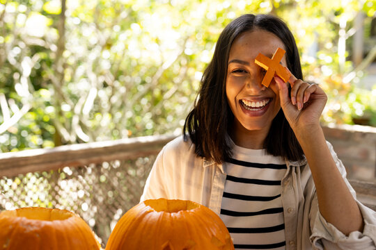 Halloween time, Carving pumpkins on deck, woman smiling and enjoying festive autumn activity