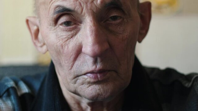 portrait of thoughtful elderly man 75 years old looking at camera inside, portrait of lonely pensioner