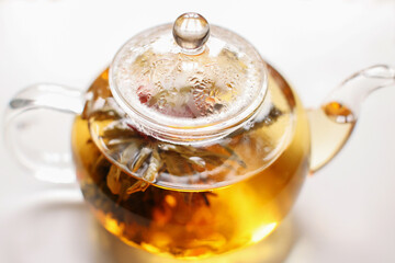 Tea leaves and citrus fruits in a glass teapot