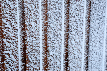 Wooden wall  after snowstorm in the winter