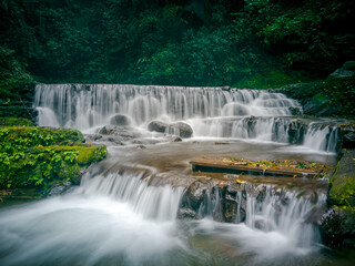 Fototapeta premium the figure of a beautiful princess depicted by a waterfall. One of the hidden gems in Kuningan.