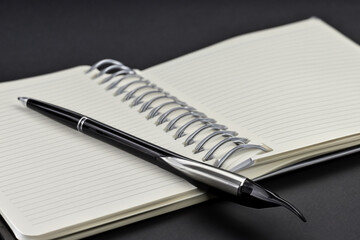 Notebook with pen in on . blank office business concept. and white notebook with pen lying on it on a . a man lies on a white with a notebook lifestyle and pen open.