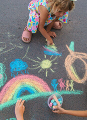 Children draw with chalk on the asphalt. Selective focus. © yanadjan