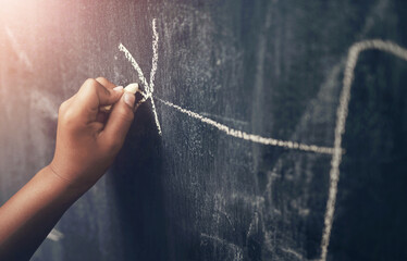 School, writing and hand of child with blackboard, chalk and creative development in education. Student, growth and kid drawing on chalkboard in classroom for art, inspiration and learning with ideas