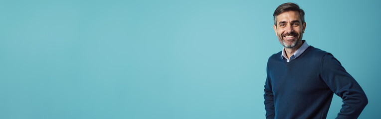 Confident mature man smiling warmly against turquoise background with copy space