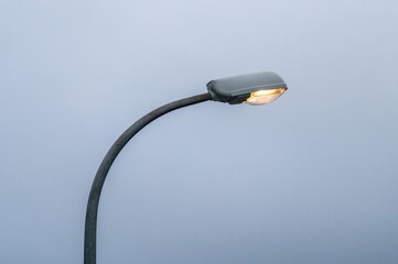 Street lamp illuminating foggy sky: minimalist urban nightscape