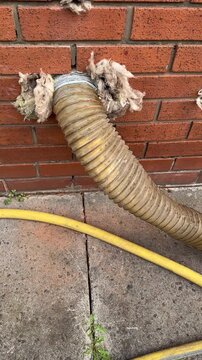 Vertical shot. Old cavity insulation material being extracted into the large sack using vacuum and compressor.