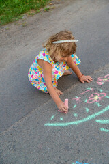 Fototapeta premium Children draw with chalk on the asphalt. Selective focus.