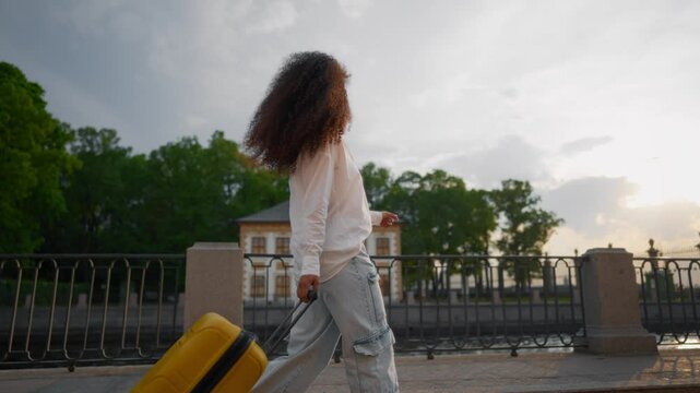 Enjoy traveling and freedom, portrait of young Arab woman tourist in city. Slender biracial lady rolling big suitcase, camera moving around from full-length back view to headshot, tourism and travel