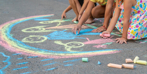 Children draw with chalk on the asphalt. Selective focus. © yanadjan