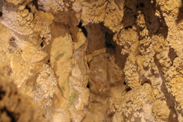 Exploring the unique textures and formations inside a natural cave at sunset, showcasing nature's artistry and geological features