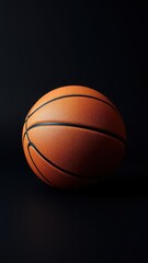 Obraz premium A basketball ball placed on a sleek black background, athletic