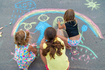 Children draw with chalk on the asphalt. Selective focus.
