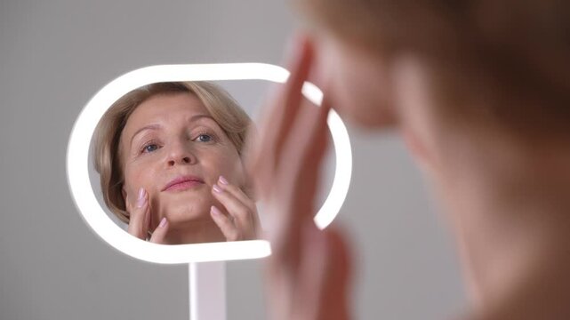 A middleaged woman moisturizing and nourishing her face during anti-aging skincare routine, embodying confidence and selflove 