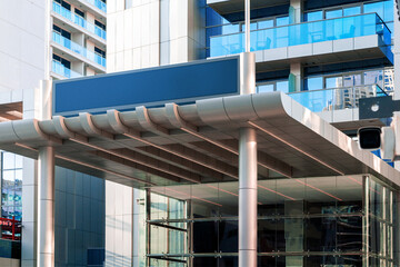 Entrance to modern hotel or apartments building with empty hotel sign. Place for text.